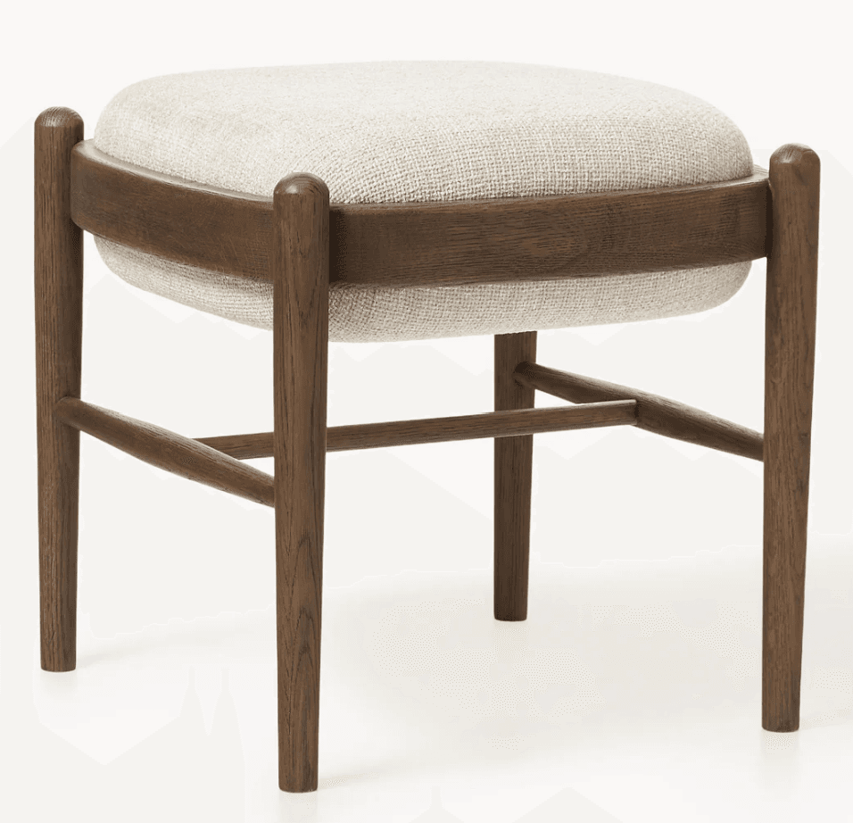 A square, upholstered ottoman featuring a solid wood frame with a dark finish and a light-colored, textured fabric cushion. The frame consists of four rounded legs connected by horizontal stretchers, with a curved wooden band supporting the plush upholstered top. — 3D model