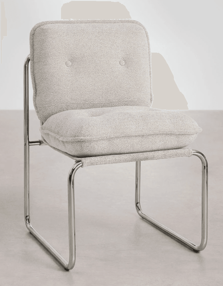 An armless chair featuring a cantilever frame constructed from polished tubular chrome. It has two separate, plush upholstered cushions for the backrest and seat, both covered in a light beige, textured bouclé-like fabric. The cushions are secured to the frame and feature central tufting, adding a subtle decorative element. The chair exhibits a minimalist yet comfortable aesthetic, characteristic of modern design. — 3D model