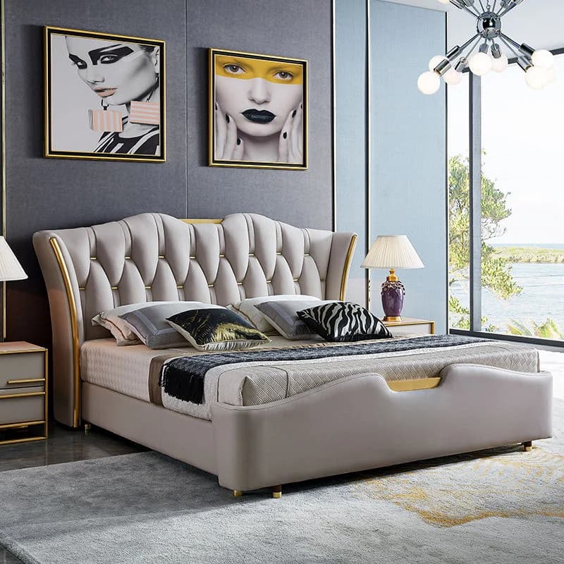 A luxurious contemporary upholstered bed frame with a distinctive wingback headboard. The headboard features deep button tufting in a beige, soft-pile fabric, accented with elegant gold-finished metal trim. The entire bed frame, including the low-profile, subtly curved footboard and side rails, is upholstered in the same beige fabric. It stands on small, gold-finished cylindrical feet. — 3D model