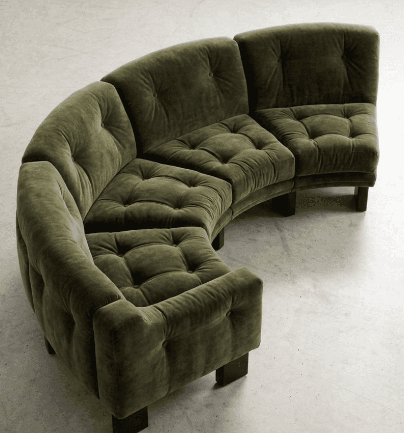 A large, modular curved sectional sofa upholstered in a plush olive green velvet fabric. The sofa is… — 3D model