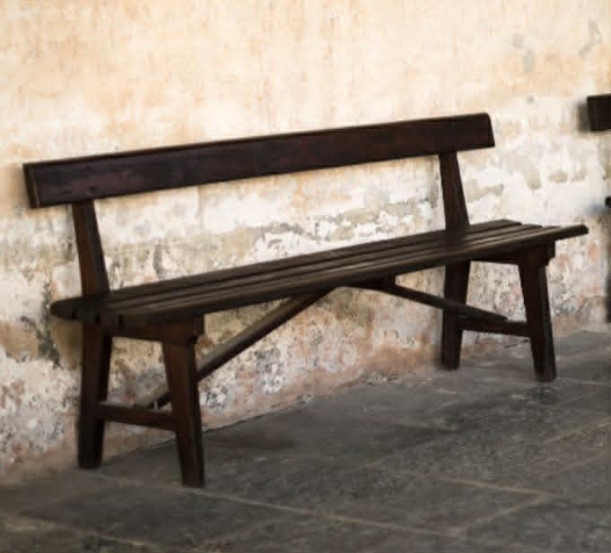 A dark brown wooden bench with a slatted seat and backrest, featuring a simple, robust design. It has four sturdy legs and is rendered against a white background. — 3D model