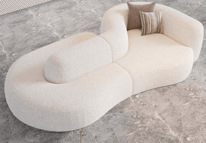 A modular, organic-shaped sofa with a textured boucle fabric upholstery. The sofa features a distinctive curved design with distinct seating sections and an integrated armrest/backrest element. Two decorative throw pillows are placed on the seating area, one solid taupe and the other with a striped pattern. — 3D model