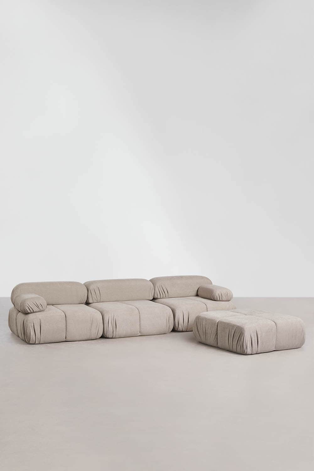 A light beige, plush modular sofa with an accompanying ottoman, featuring a contemporary design with… — 3D model