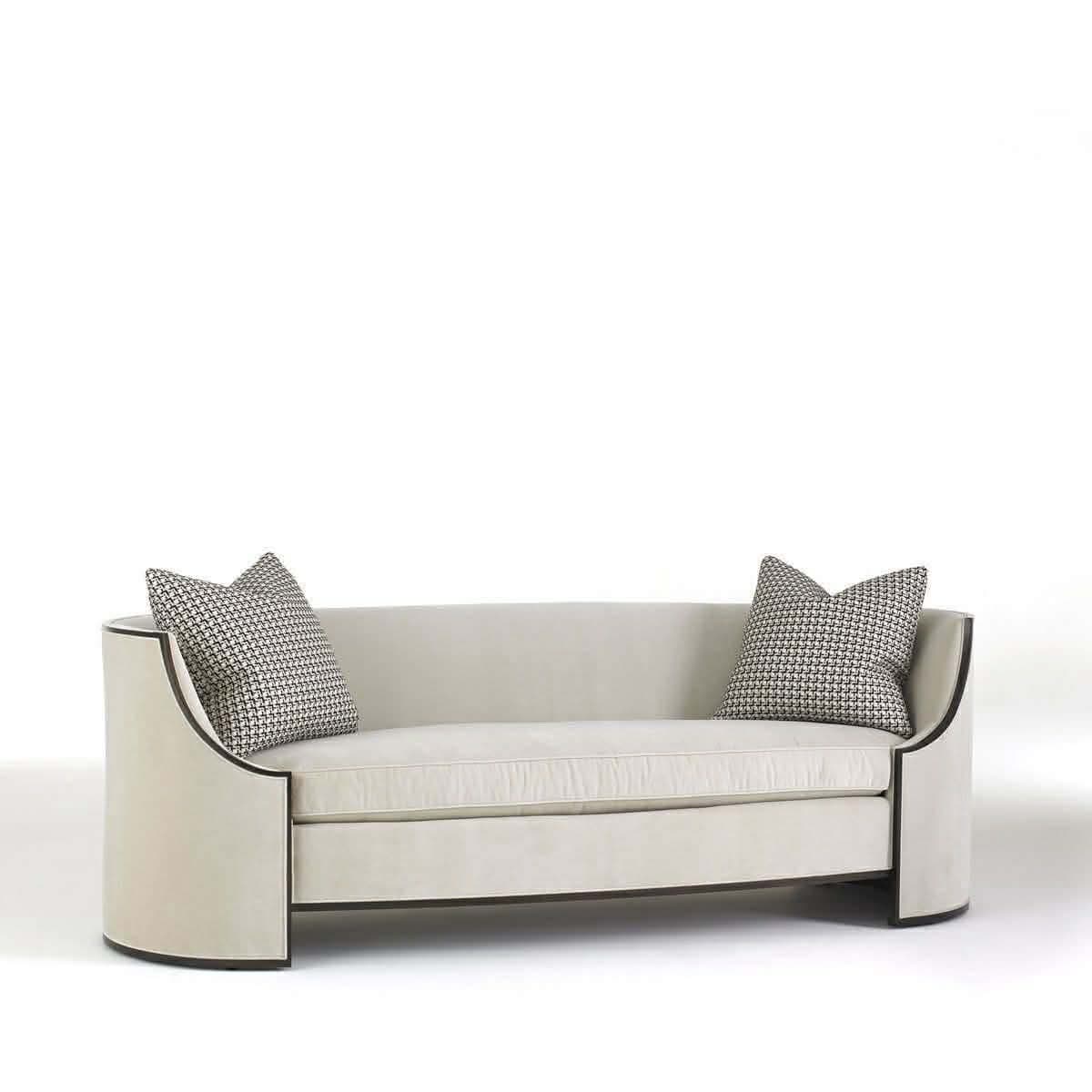 A modern two-seater sofa featuring a continuous curved back and integrated arms, upholstered in a light-colored fabric. The design includes a subtle dark trim along the bottom edge and the outer frame of the arms, giving it a sleek, contemporary profile. Two patterned throw pillows are included. — 3D model