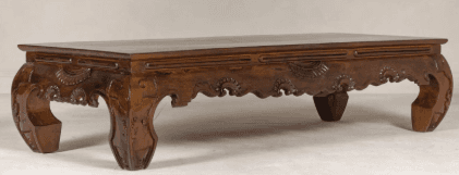 A low-profile rectangular table crafted from dark wood, featuring extensively carved details along its apron and legs. — 3D model