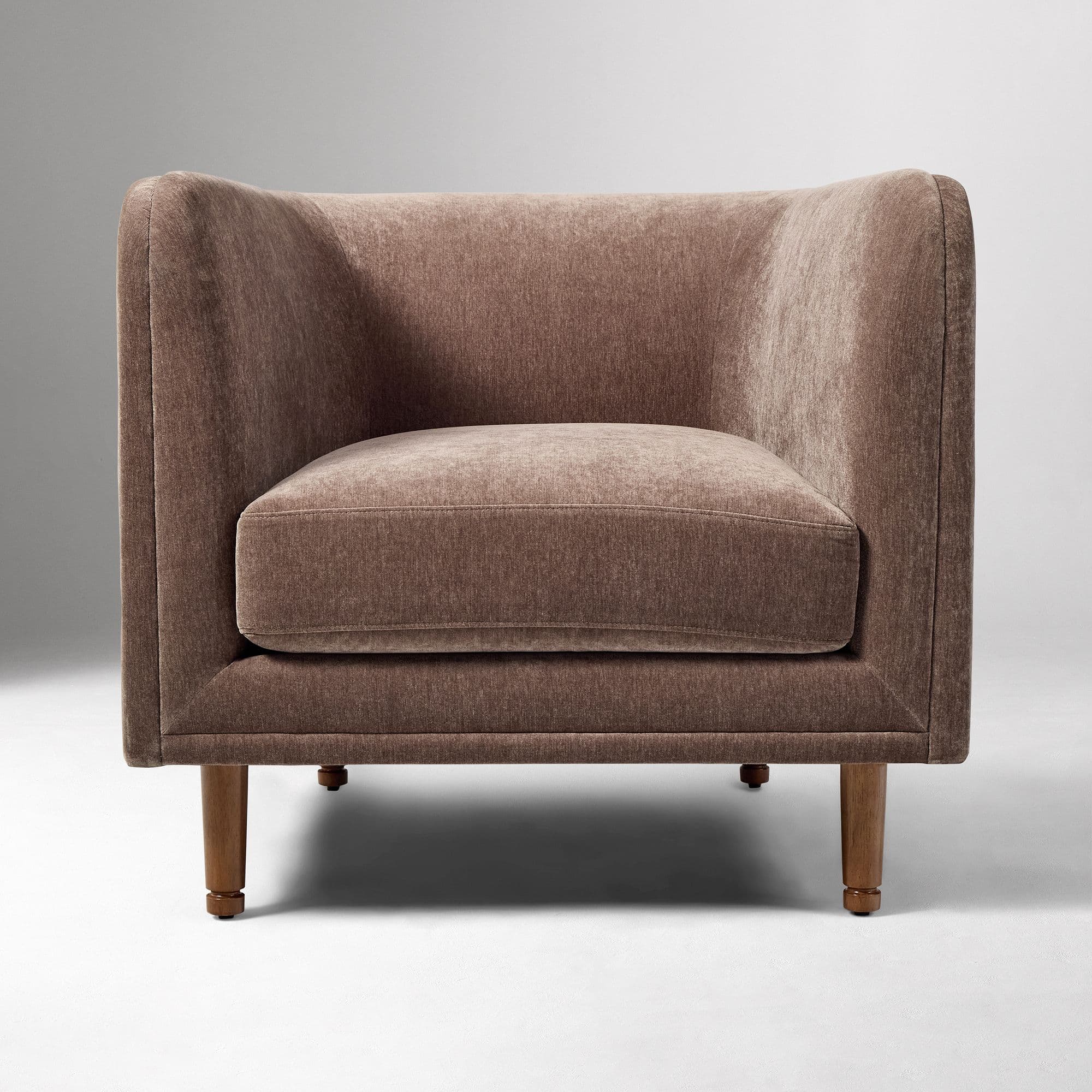 A contemporary upholstered club armchair featuring a single, removable seat cushion, integrated flared arms, and a low back, all covered in a textured, brown fabric. The chair stands on four tapered wooden legs. — 3D model