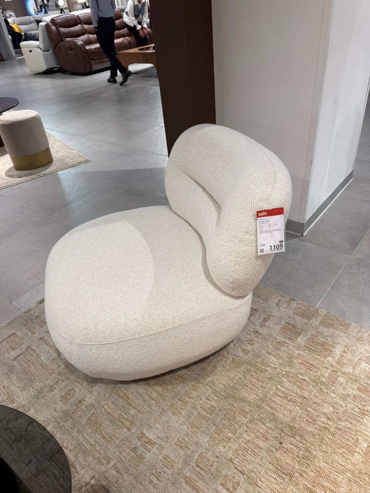 A minimalist, armless lounge chair featuring a plush, rounded seat and a low, curved backrest, all upholstered in a light-colored, textured fabric. — 3D model
