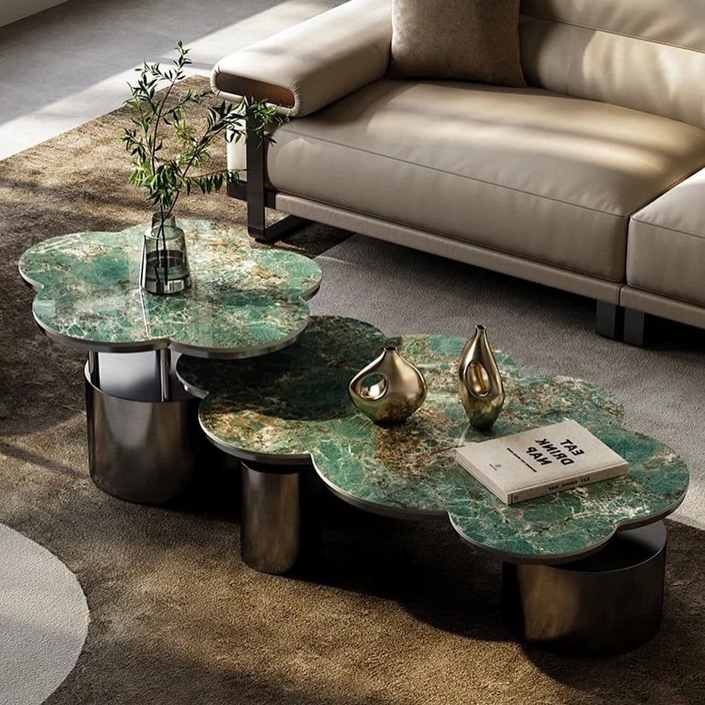 A contemporary coffee table featuring multiple cloud-shaped tops made from green and brown veined marble, supported by dark cylindrical metal bases. The tops are arranged at varying heights and slightly overlap, creating a multi-level surface. — 3D model