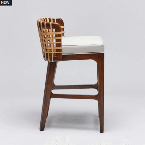 A modern bar stool with a wooden frame and a woven backrest. The seat is upholstered in a light-colored fabric. The stool has a tall profile, suitable for bar height counters. — 3D model