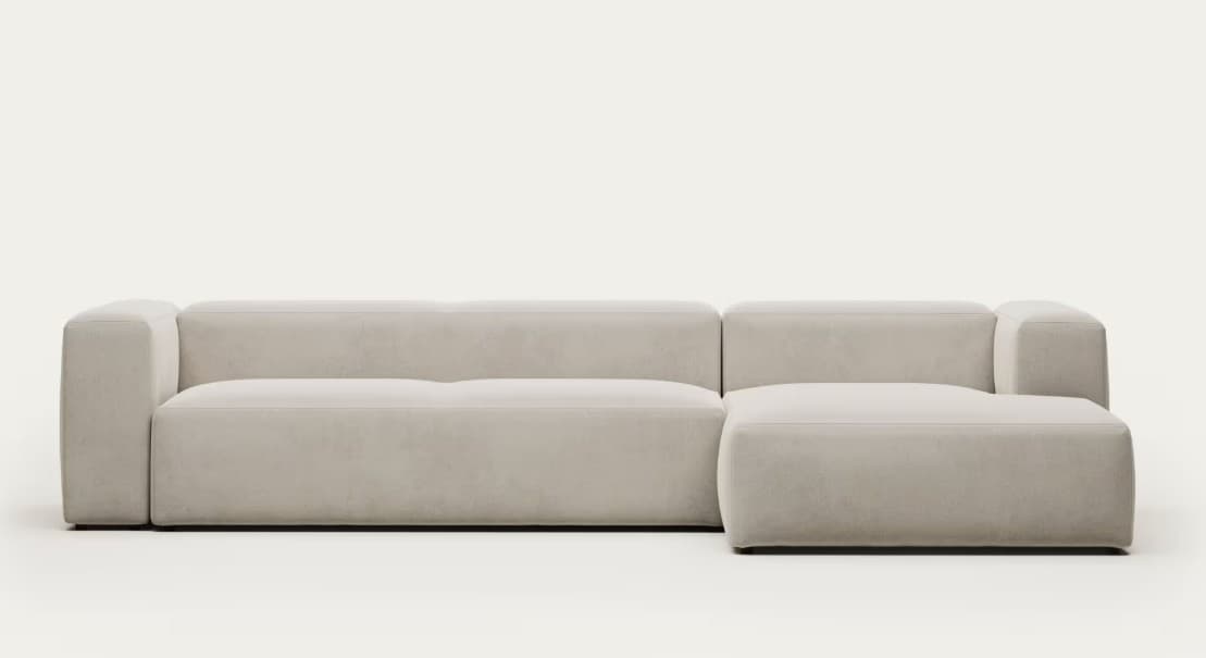 A modular sectional sofa with a chaise lounge attachment. The sofa features a low profile with rounded, padded arms and back. The upholstery appears to be a soft fabric. The sectional configuration suggests it can be arranged in different configurations. — 3D model