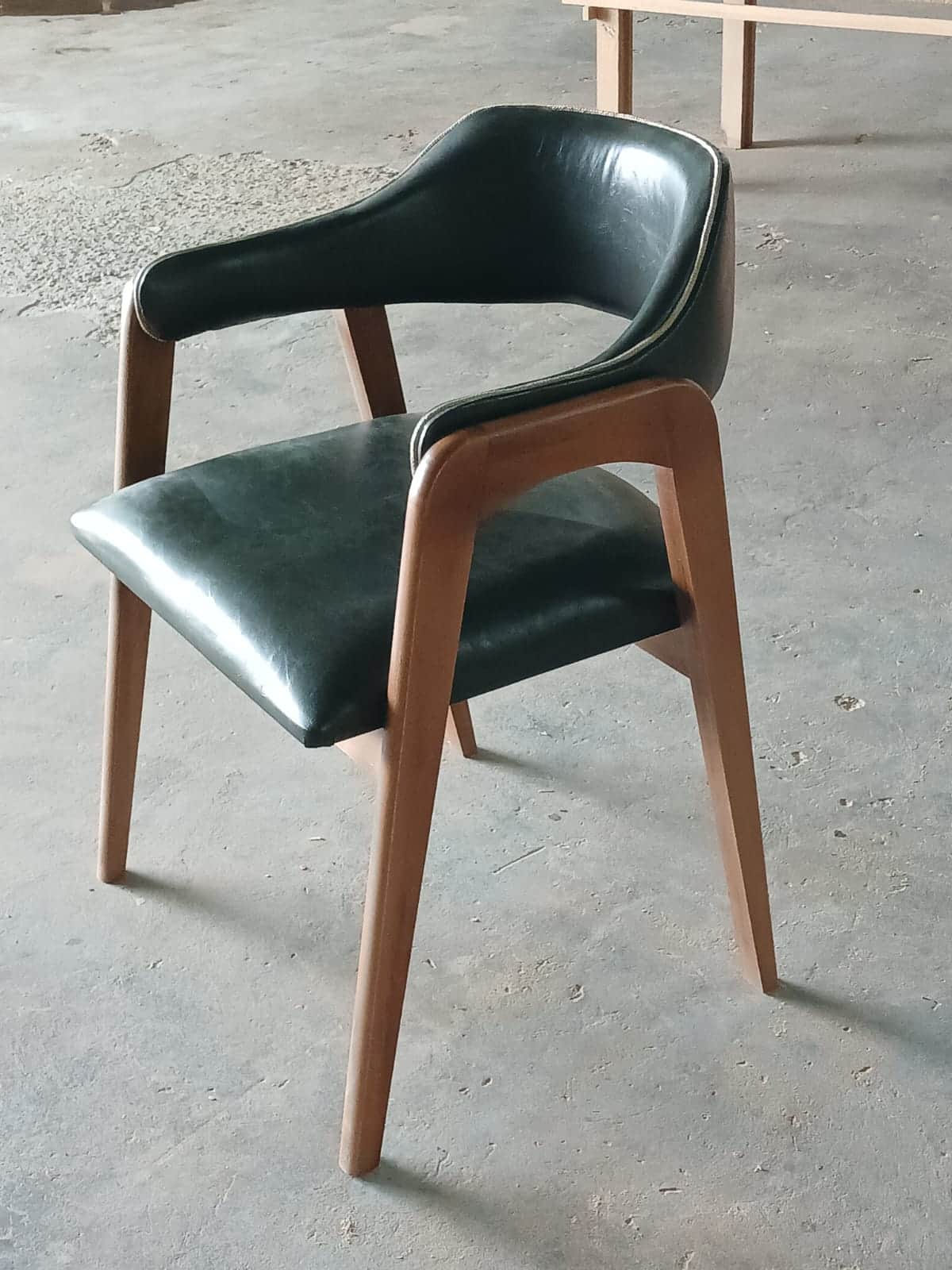 A contemporary armchair featuring a dark green upholstered seat and back with a light-toned wooden f… — free STL 3D model