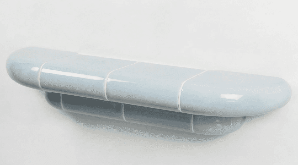 A pill-shaped, wall-mounted shelf constructed from glossy light blue ceramic or tiled elements. The… — 3D model