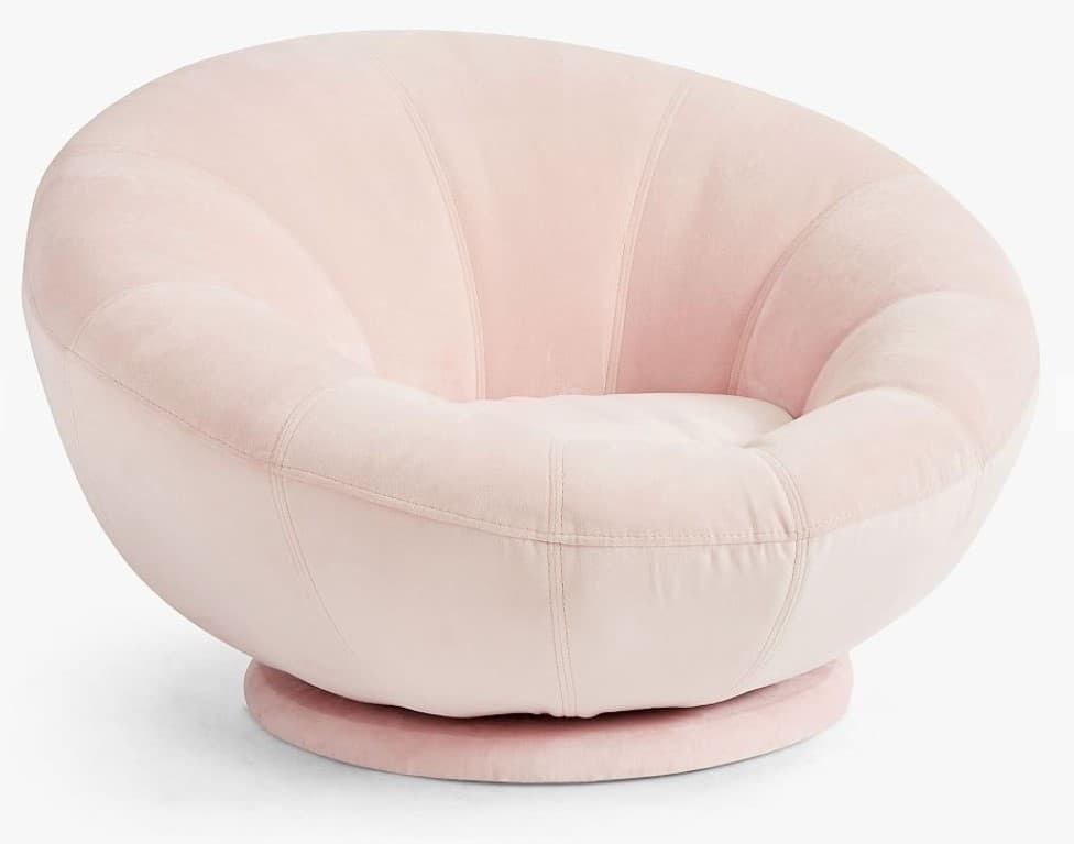 A plush, light pink armchair with a rounded, bowl-like seat and back. The upholstery features vertical channel tufting on the backrest and a smooth seat cushion. The chair is supported by a circular, swivel base. — 3D model