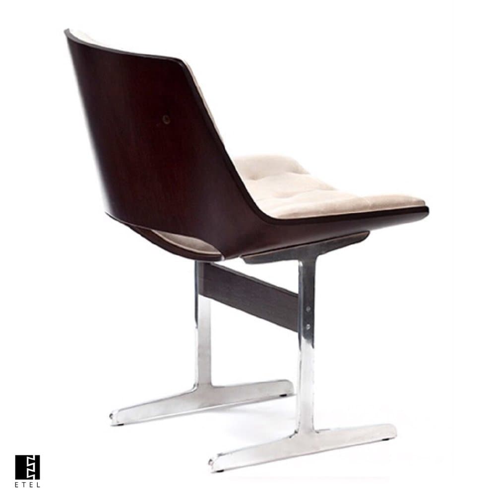 A modern armchair with a sculpted, dark wood shell back and seat, supported by a polished chrome base. The seat features a light-colored, tufted upholstered cushion. — 3D model