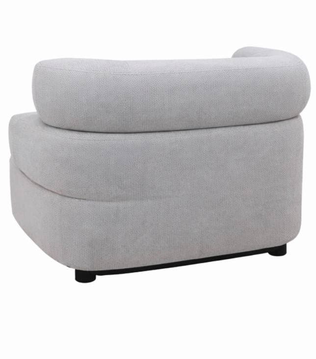 A contemporary armchair with a rounded, enveloping design. The chair features a thick, upholstered seat and backrest with a curved, continuous form. The base is low-profile, supported by small, dark legs. — 3D model