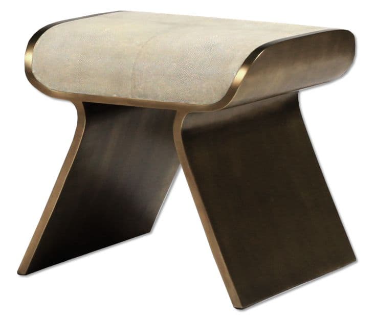 A modern stool with a curved, sculptural base and a padded, textured seat. The base appears to be made of metal with a brushed or antiqued finish, forming two intersecting arcs that provide stability. The seat is upholstered in a material with a fine, granular texture and a light, neutral color, bordered by a thin, polished metallic trim that echoes the base material. — 3D model