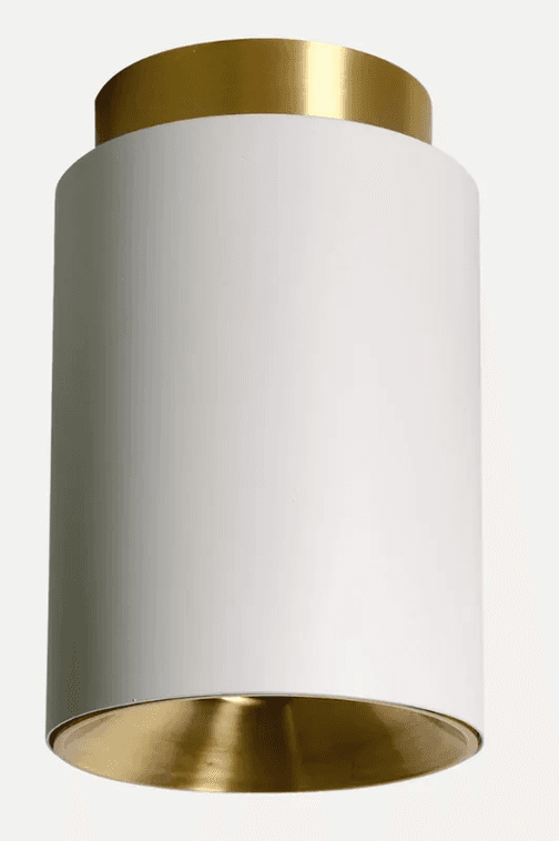 A modern cylindrical light fixture designed for semi-flush ceiling mounting, featuring a matte white exterior and a contrasting polished brass interior reflector and top trim. — 3D model