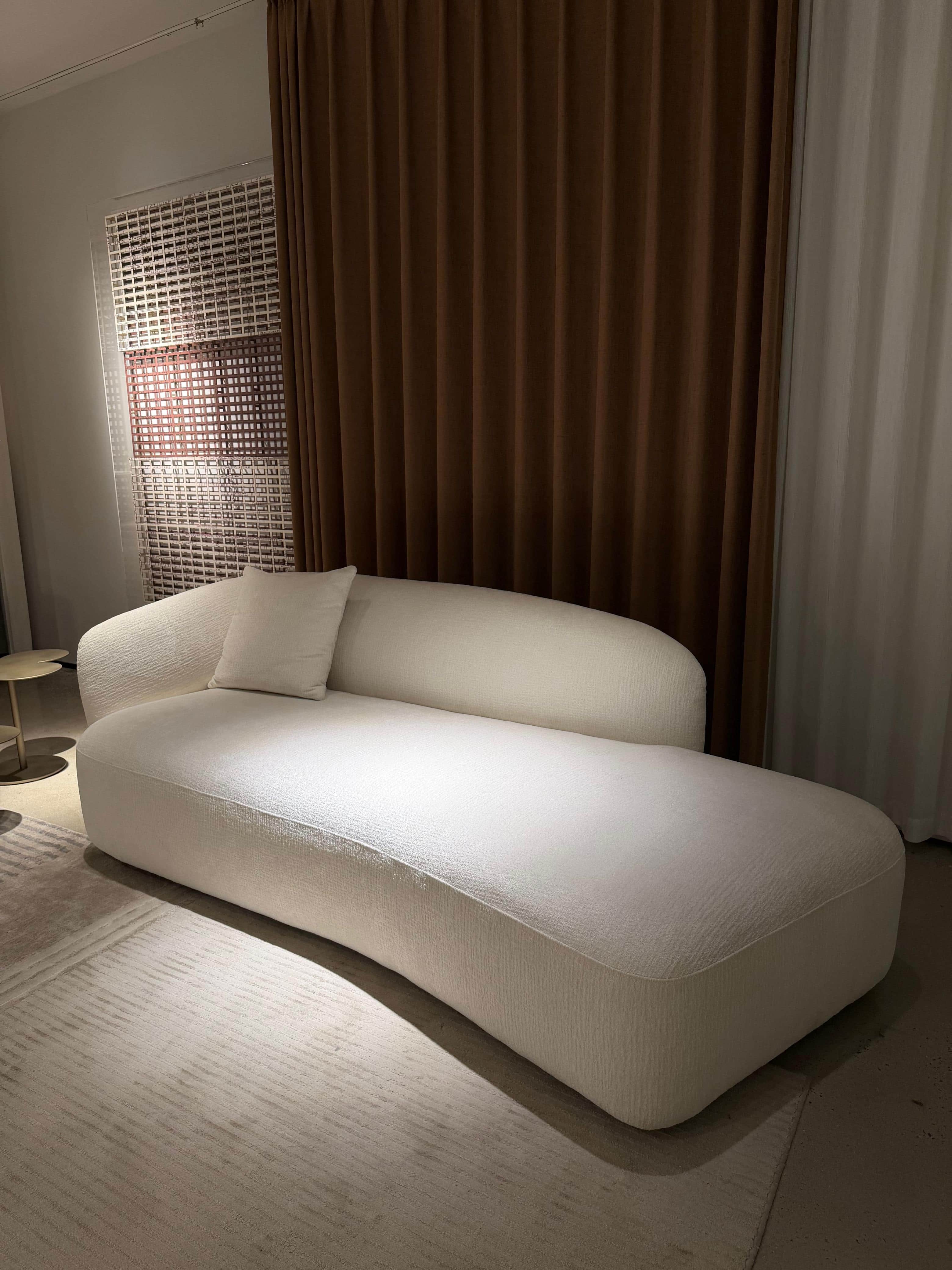 An asymmetrical upholstered chaise lounge in a cream-colored textured fabric, featuring a single int… — 3D model
