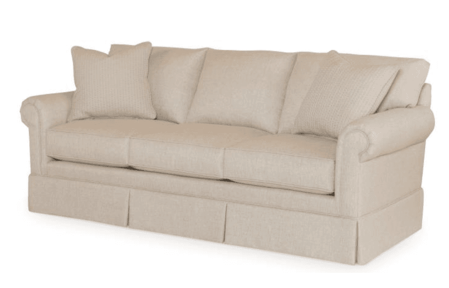 A traditional three-seater sofa upholstered in a light beige fabric, featuring rolled arms, a skirted base, and loose back and seat cushions, accompanied by two accent pillows. — 3D model