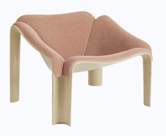 A uniquely shaped armchair with a flowing, organic design. The seat and backrest are upholstered in a textured, rose-colored fabric. The frame and legs appear to be made of a molded, cream-colored material with a smooth, glossy finish. — 3D model