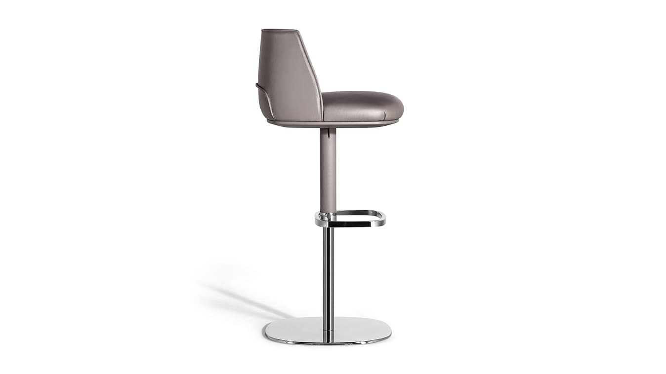 A modern bar stool featuring a padded, upholstered seat and a supportive backrest. It has an adjustable height mechanism with a single central column, a rectangular-shaped footrest, and a circular, flat base, all finished in a polished chrome or similar metal. The upholstery appears to be a grey or taupe leather or high-quality synthetic. — 3D model