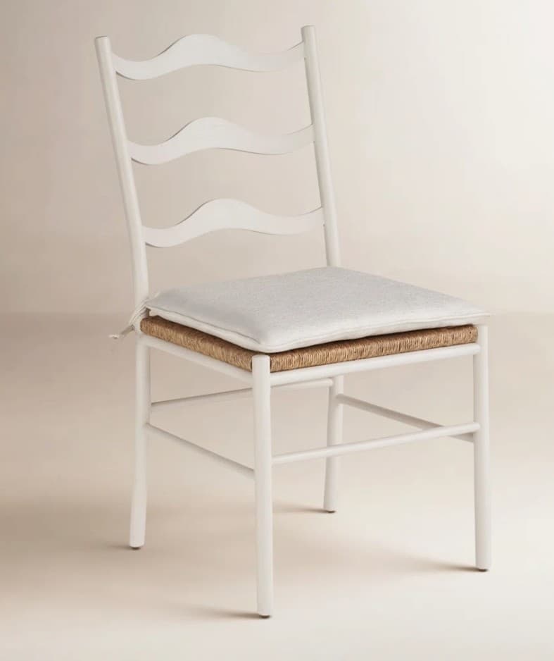 A white painted wooden chair featuring a wavy ladder-style backrest and a natural woven rush seat, topped with a light-colored cushion. — 3D model