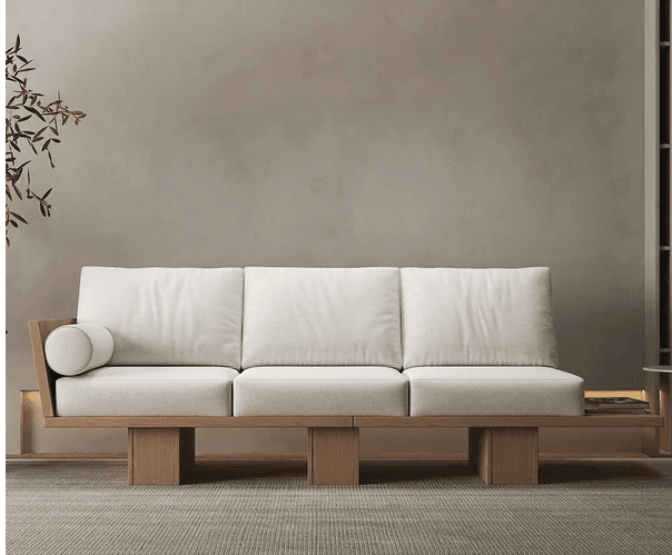 A modern three-seater sofa featuring a distinctive light wood platform frame and off-white upholstered cushions. It includes an integrated side table extension on one end, and a wooden armrest with a bolster on the other. — 3D model