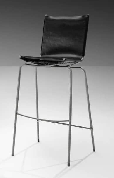 A bar stool with a black seat and backrest, supported by a thin, metallic frame with four legs conne… — 3D model