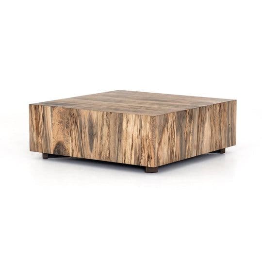 A square coffee table with a block-like design, featuring a surface and sides constructed from wood with a prominent grain pattern. The piece is elevated by four small, dark-colored feet. — 3D model