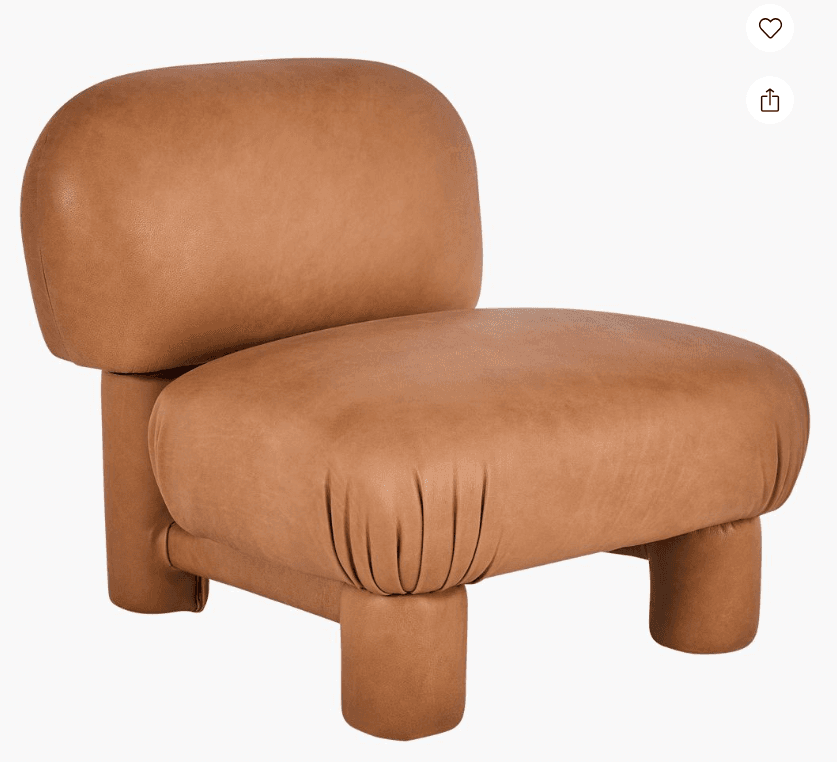 A contemporary, armless chair upholstered in tan leather, featuring a low-profile, plush, and rounded form factor. The design incorporates a distinct backrest and seat, both generously padded, resting on four short, cylindrical legs. The upholstery exhibits subtle gathering details, particularly around the front of the seat. — 3D model
