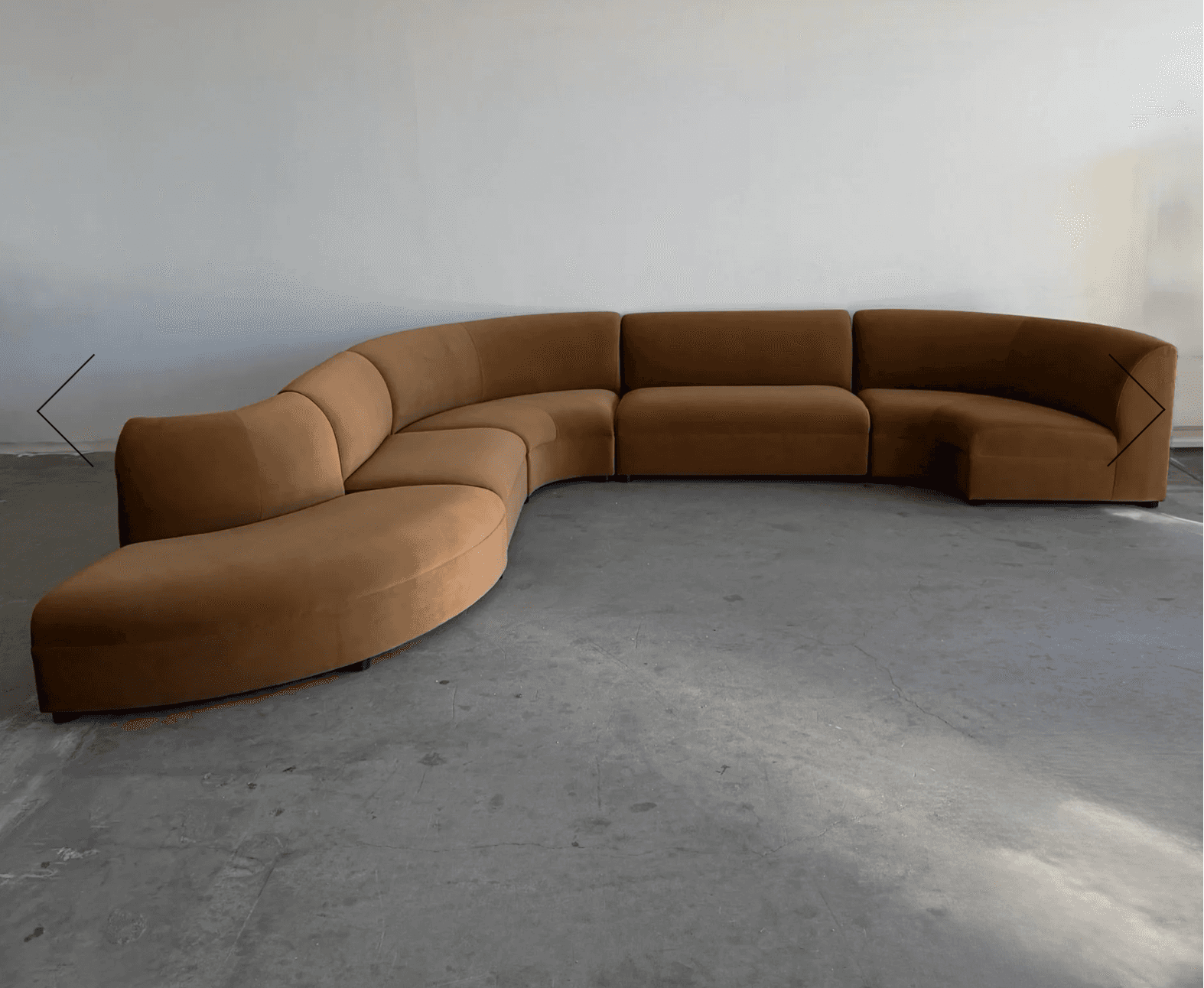 A large, modular, curved sectional sofa with a low profile and rounded edges. It appears to be uphol… — 3D model