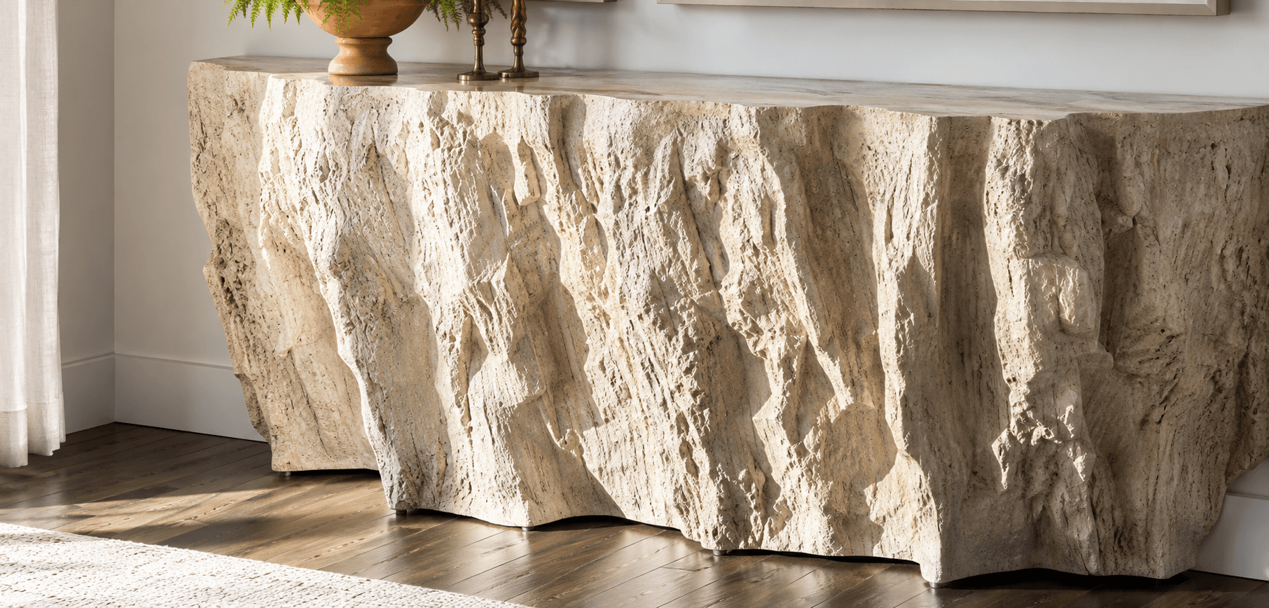 A console table featuring a minimalist rectangular top and a highly textured, irregular front surface, resembling a natural stone slab or rock formation. The material appears to be a light-colored stone composite. — 3D model