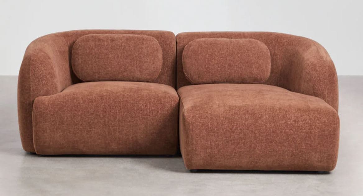 A modern, two-seater loveseat with a modular design, upholstered in a rust-colored woven fabric. It features soft, rounded contours, integrated arms and back, and two loose cylindrical back cushions. — 3D model