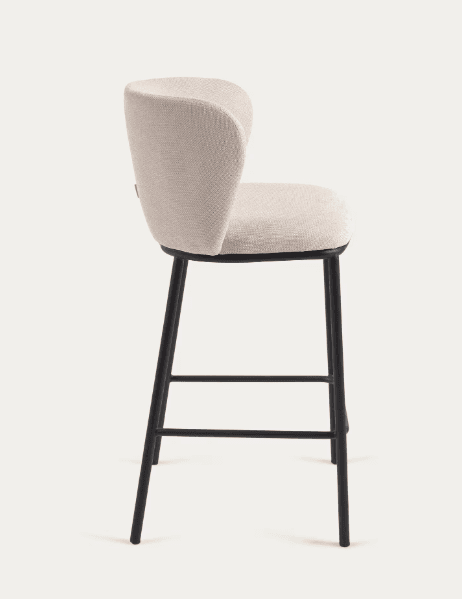 A modern upholstered bar stool with a curved backrest and a black metal frame. The seat and back are covered in a textured, light-colored fabric. The frame consists of four slender legs connected by horizontal supports for stability. — 3D model