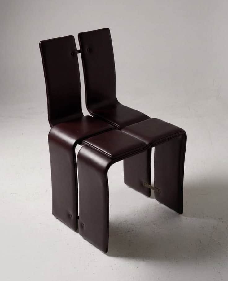 A two-person modular seating unit upholstered in dark brown leather, featuring continuous curved for… — 3D model