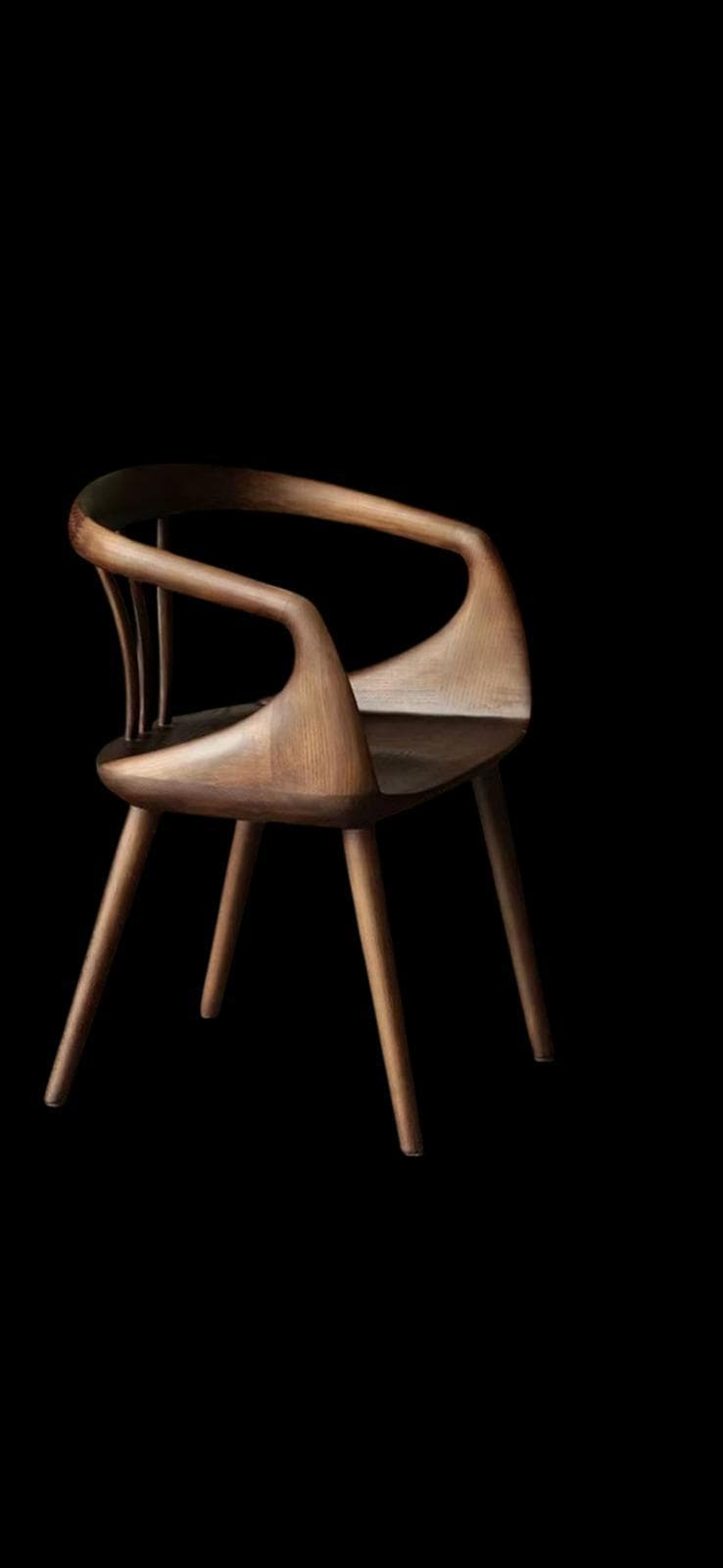 A wooden armchair with a curved backrest and armrests, supported by four tapered legs. The design features organic, flowing lines and a visible wood grain. — 3D model