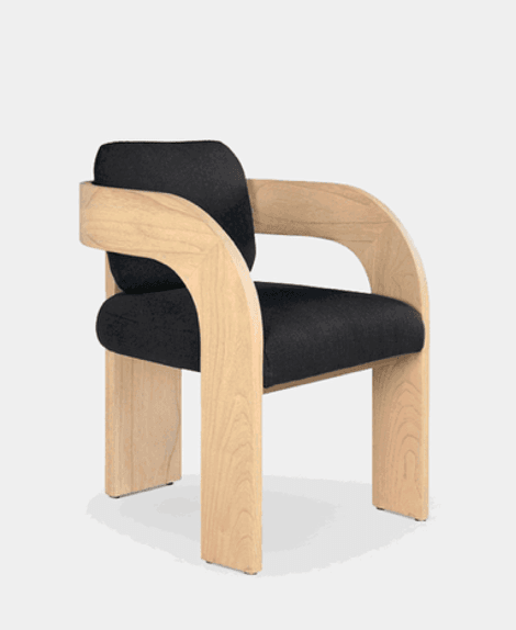A modern armchair featuring a robust, light-toned wooden frame that integrates the armrests, backrest support, and legs into a single, fluid design. The seat and separate backrest cushion are upholstered in a dark fabric. — 3D model