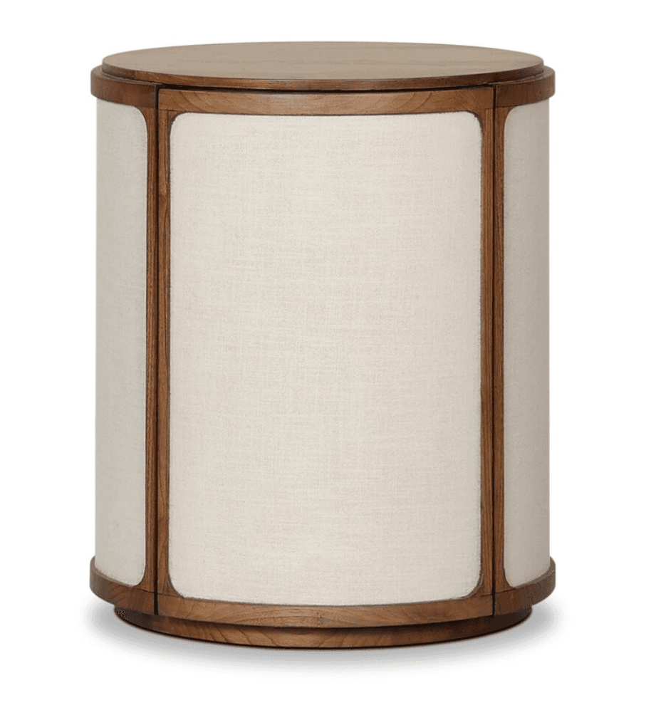 A cylindrical side table featuring a flat wooden top and a matching wooden base. The body is constructed from multiple vertical panels, each framed with wood and upholstered with a light-colored, textured fabric. — 3D model