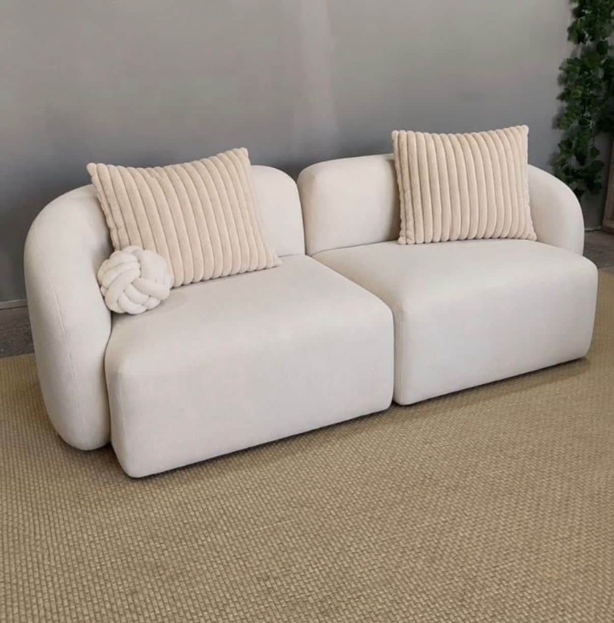 A modern two-piece modular sofa featuring a soft, rounded silhouette upholstered in a cream-colored… — free GLB 3D model