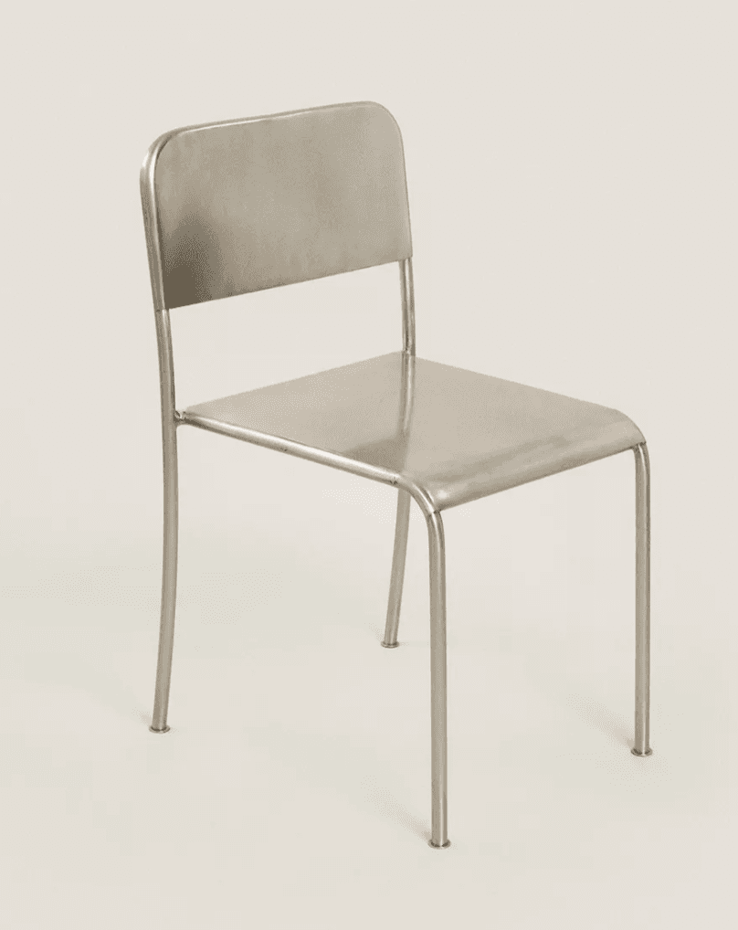 A minimalist, modern armless chair constructed entirely from metal, featuring a tubular frame, a flat rectangular seat, and a slightly curved rectangular backrest. All edges are rounded, and the chair has a uniform metallic finish. — 3D model