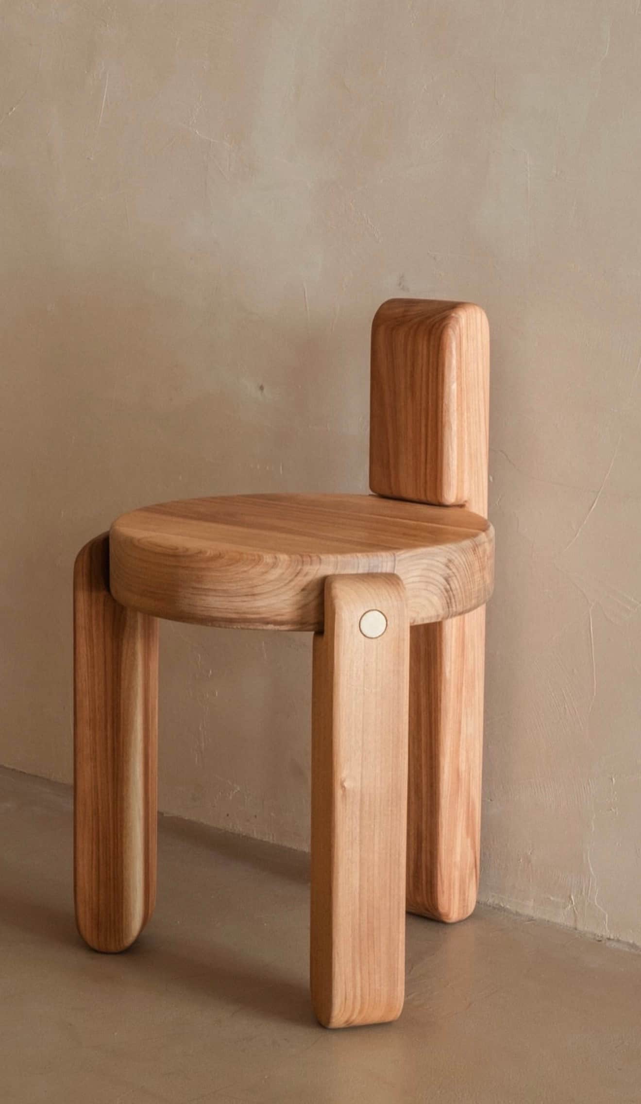 A minimalist, light-toned wood chair featuring a circular seat and a short, rectangular backrest. Th… — 3D model