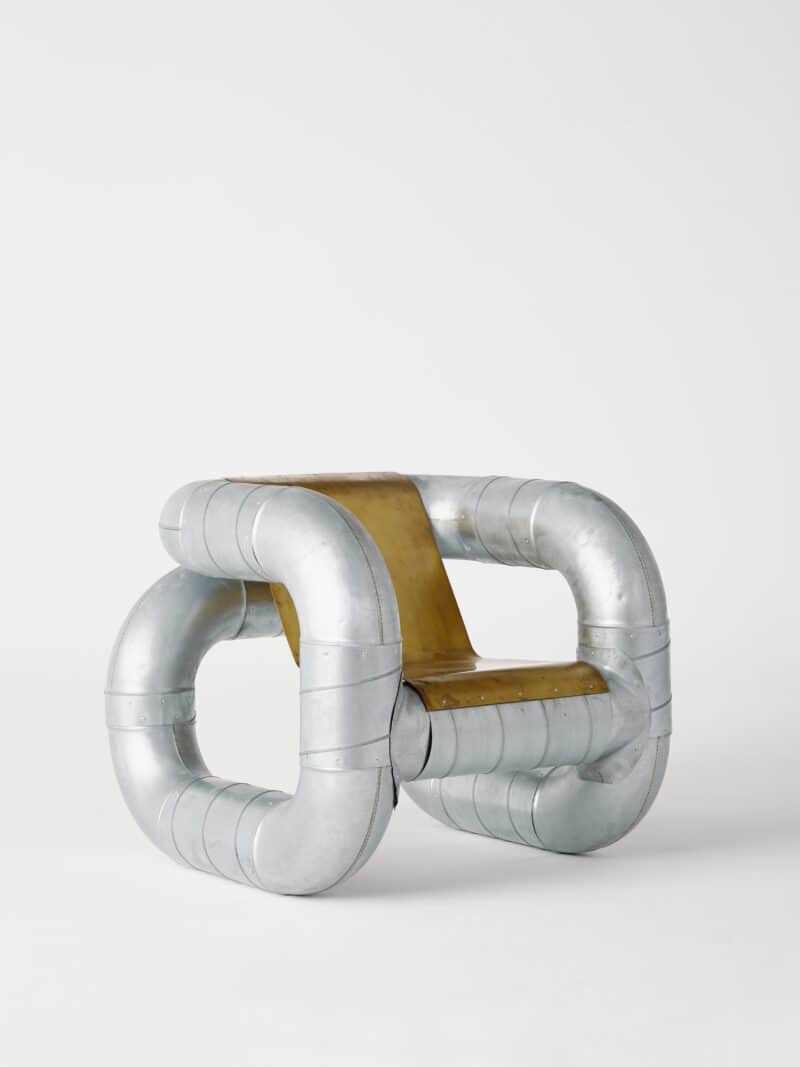 An avant-garde chair constructed from large diameter, curved metal pipes joined together to form a u… — 3D model