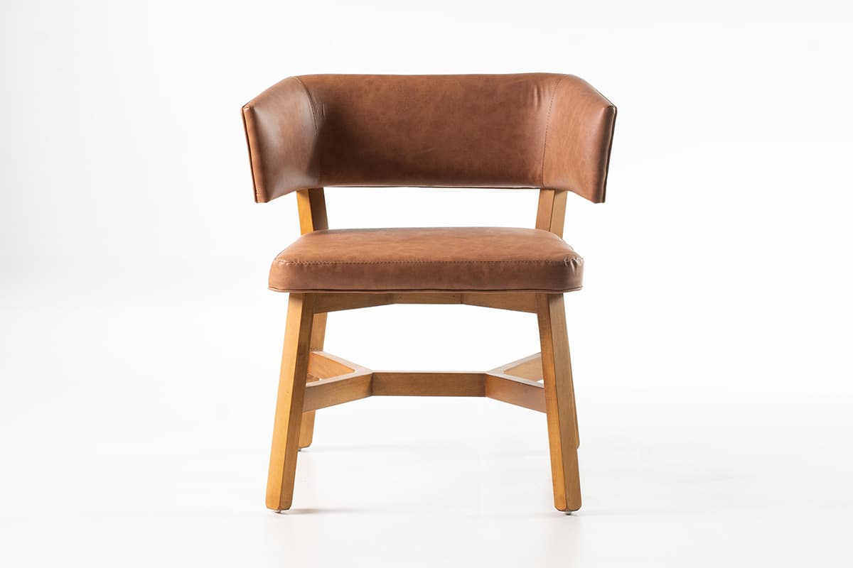 A brown upholstered chair with a light-colored wooden frame, featuring a curved backrest that subtly extends to form slight armrests. The seat and backrest are covered in a textured material resembling faux leather, with visible stitching. The chair stands on four straight legs reinforced by cross stretchers. — 3D model