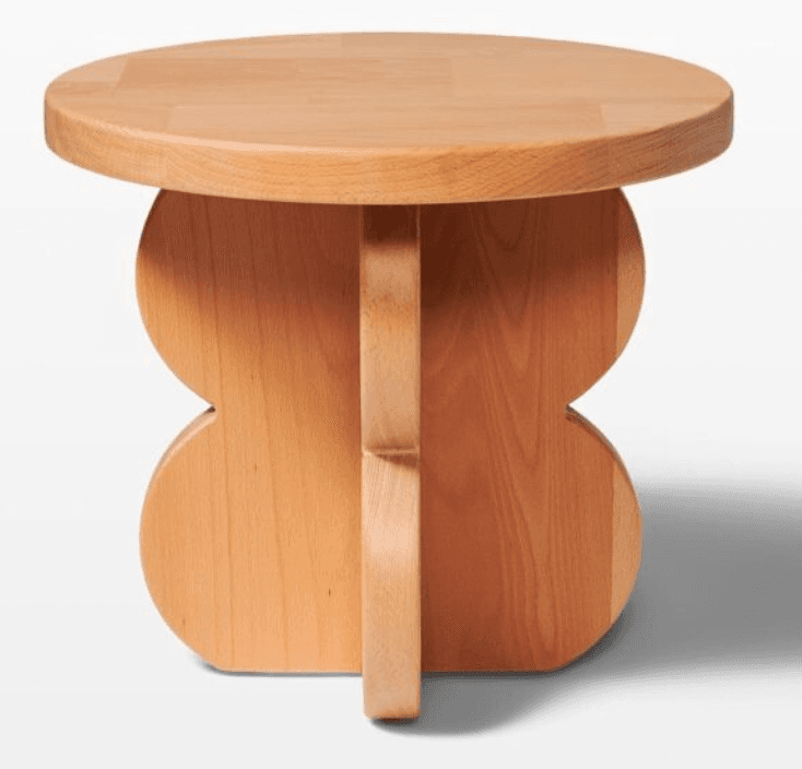 A round-topped side table with a distinctive base composed of two interconnected, symmetrical curvilinear elements, resembling a stylized butterfly or hourglass shape. A vertical central support connects the tabletop to the base. The overall construction appears to be solid wood. — 3D model