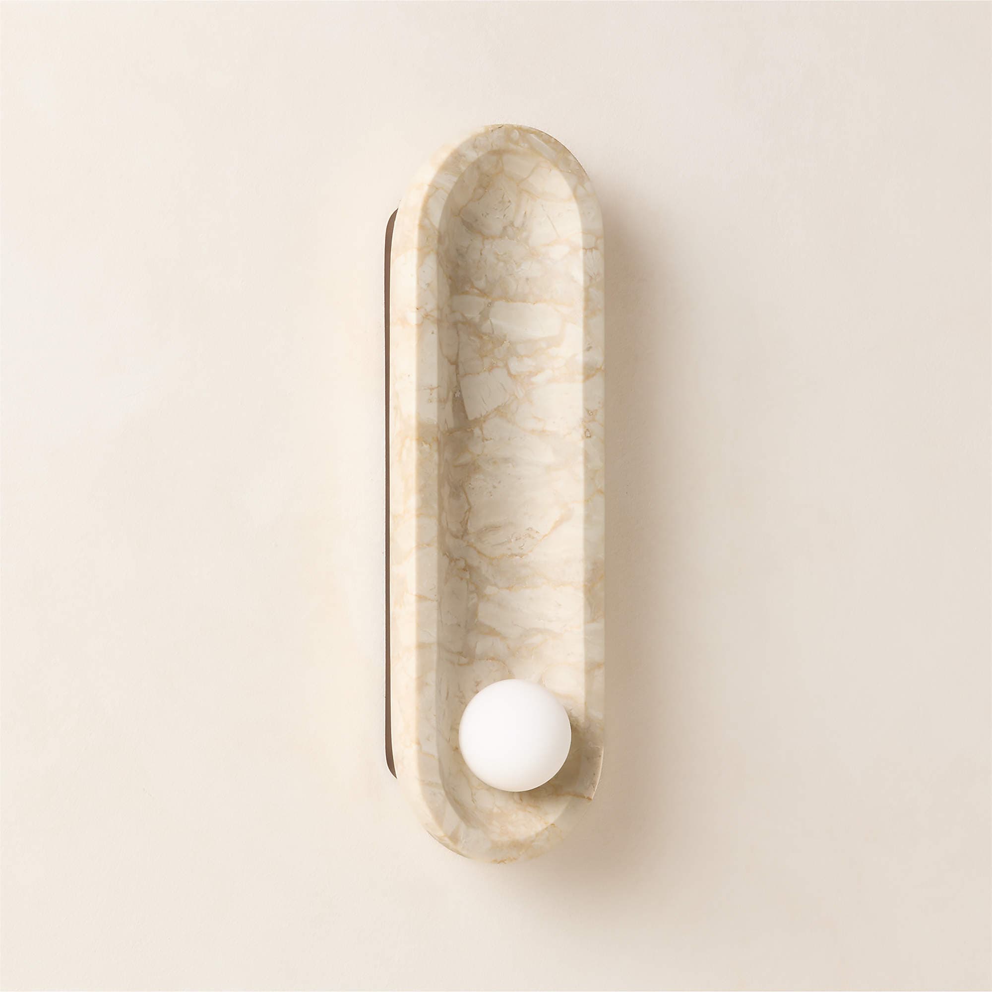 An elongated, capsule-shaped wall sconce made from light-colored marble with prominent grey veining, featuring a single spherical opal glass diffuser positioned towards the lower end. The design is modern and minimalist. — 3D model