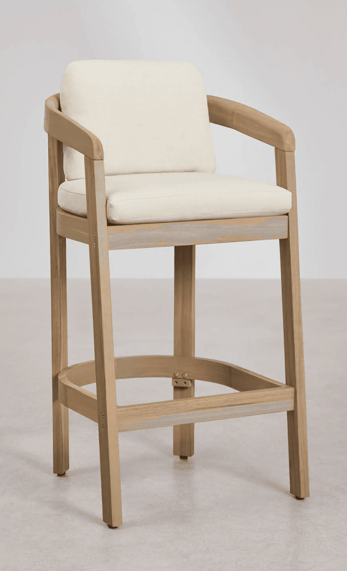 A wooden bar stool with a light wood finish. It features a rectangular seat and backrest, both upholstered in a cream-colored fabric. The stool has four legs connected by a circular footrest. The armrests are integrated into the frame, curving downwards from the backrest supports. — 3D model