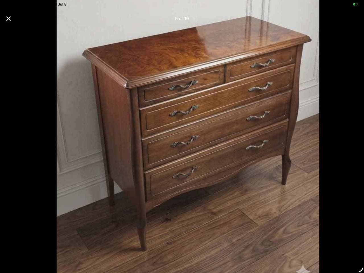 A Baroque-style chest of drawers crafted from rich brown wood, featuring a distinctive burl wood veneer top. The cabinet has a curved front profile with a total of five drawers, two smaller ones at the top and three larger ones below, each adorned with ornate antique brass pull handles. The piece is supported by elegant cabriole-style legs. — 3D model