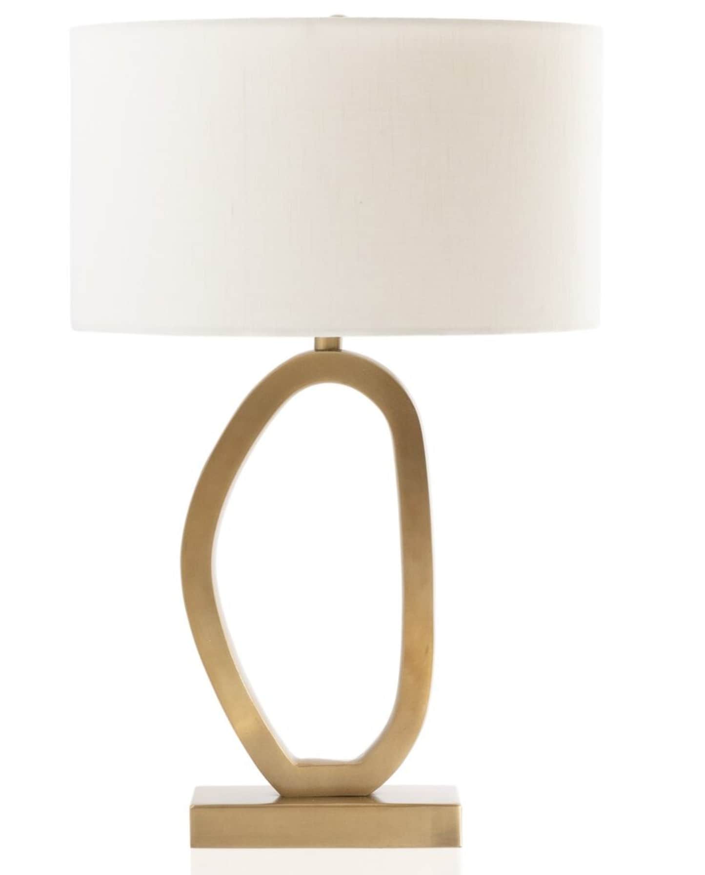 A modern table lamp featuring a sculptural, loop-shaped metal base with a brushed gold finish, suppo… — 3D model