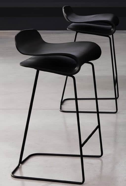A modern black bar stool with a distinctive, flowing seat that curves upwards at the edges. The seat… — 3D model