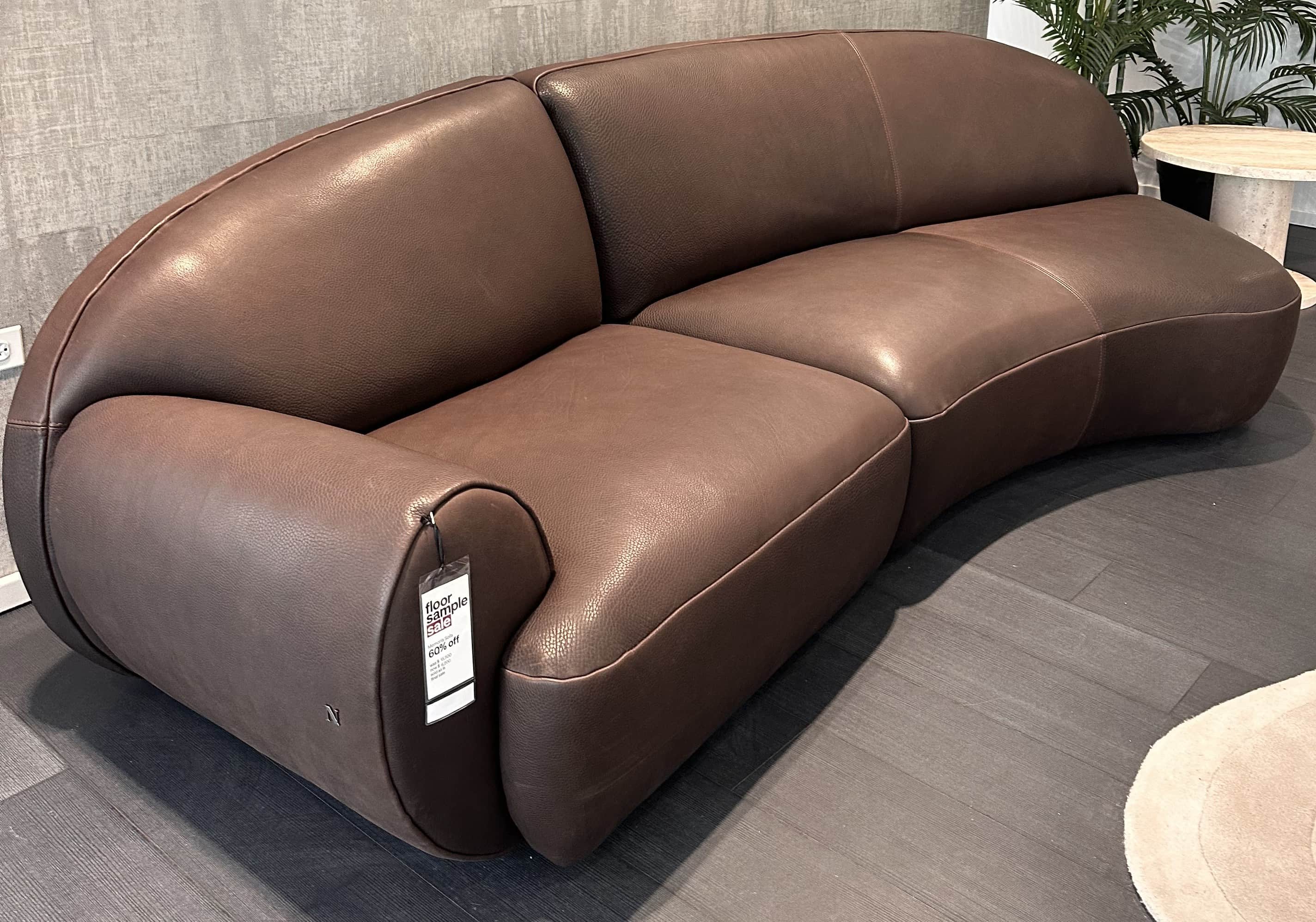 A curved sectional sofa upholstered in brown leather. The sofa has a low profile with plush, rounded… — free OBJ 3D model